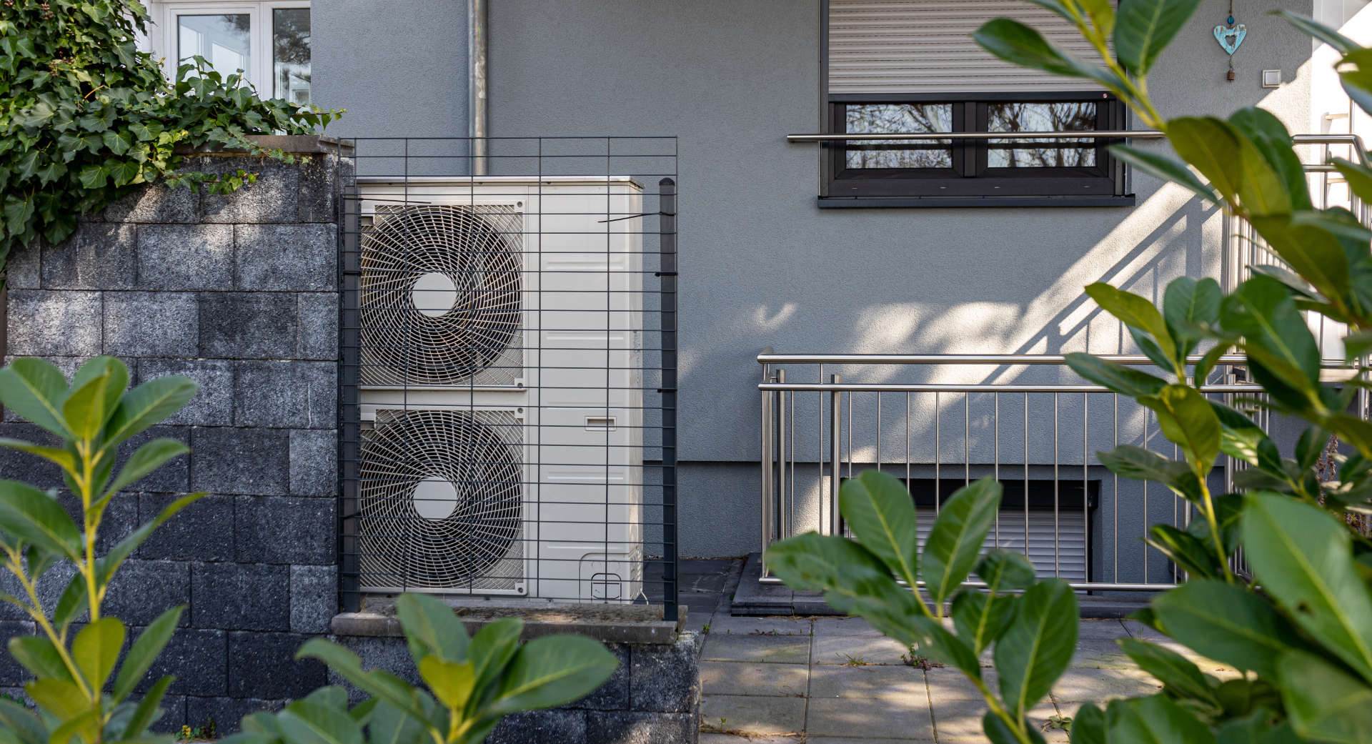 Air source heat pumps installed on the garden front of a modern house